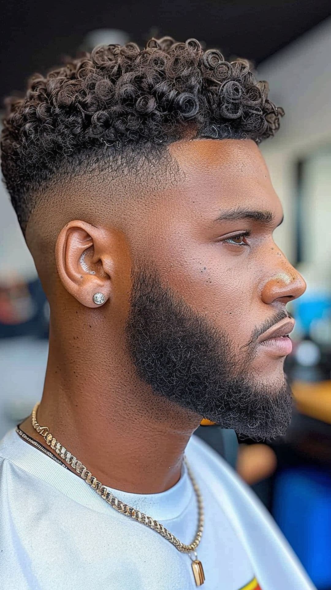 A black man modeling a curly top with a fade haircut.