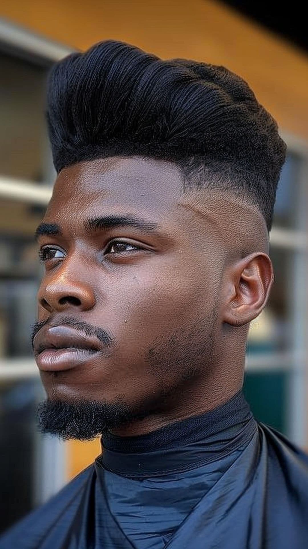 A black man wearing a pompadour haircut.