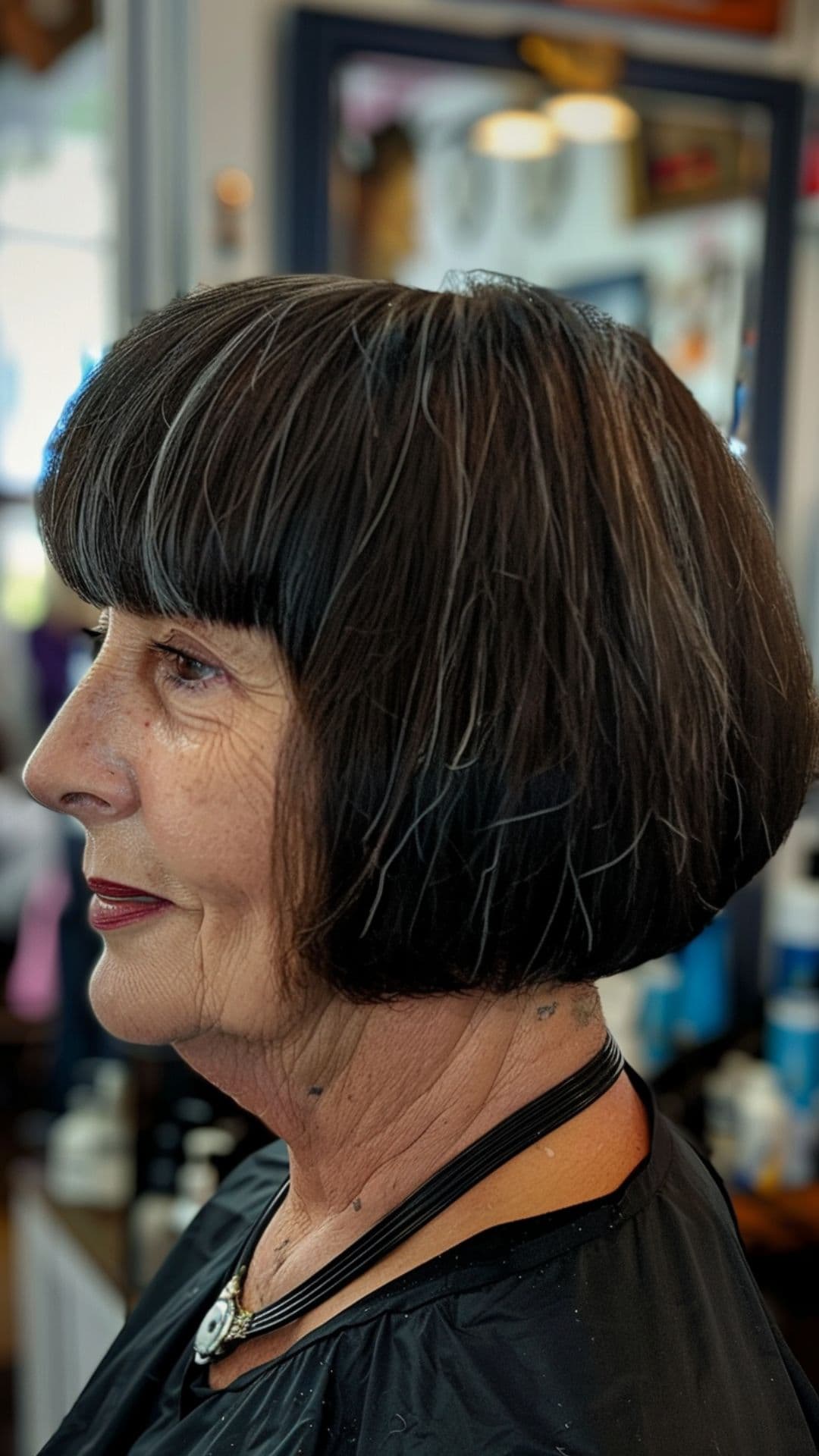 An old woman shaping blunt bangs.