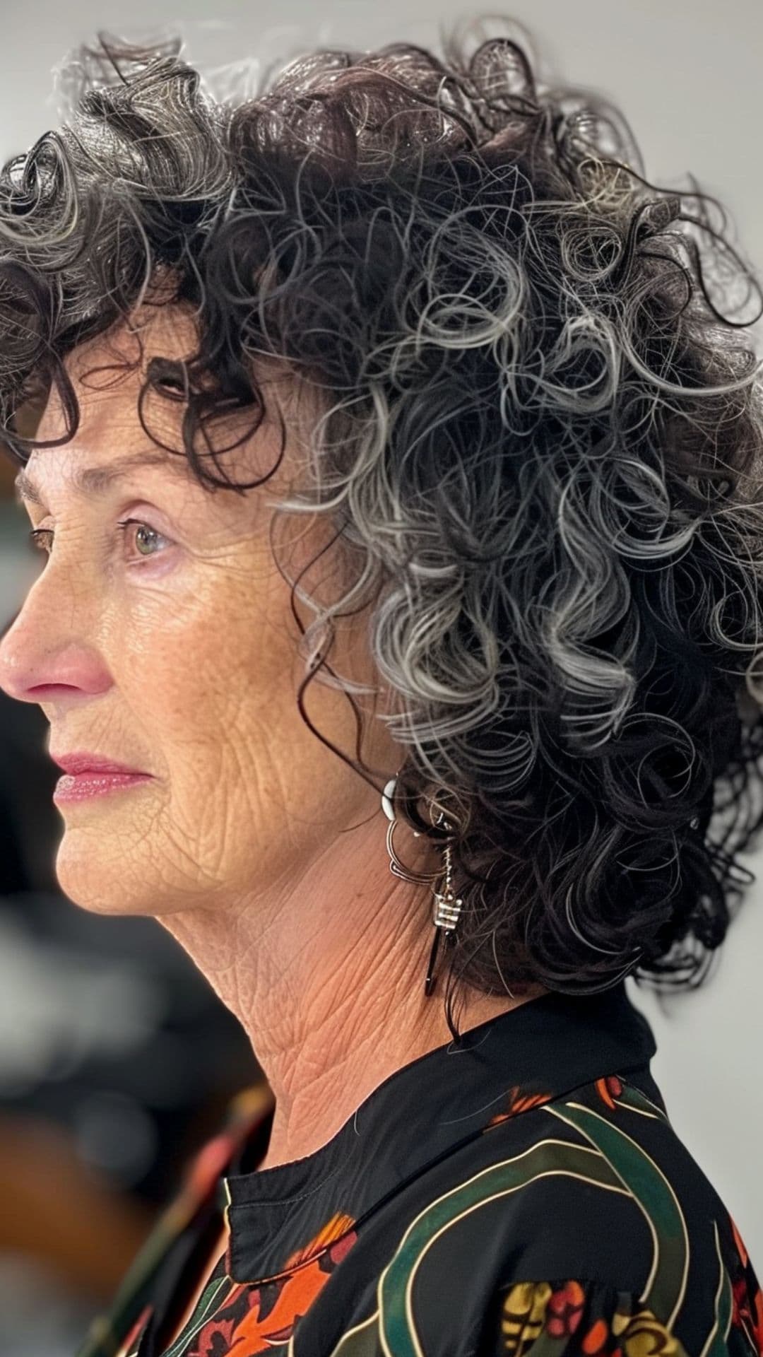 An old woman shaping curly bangs.